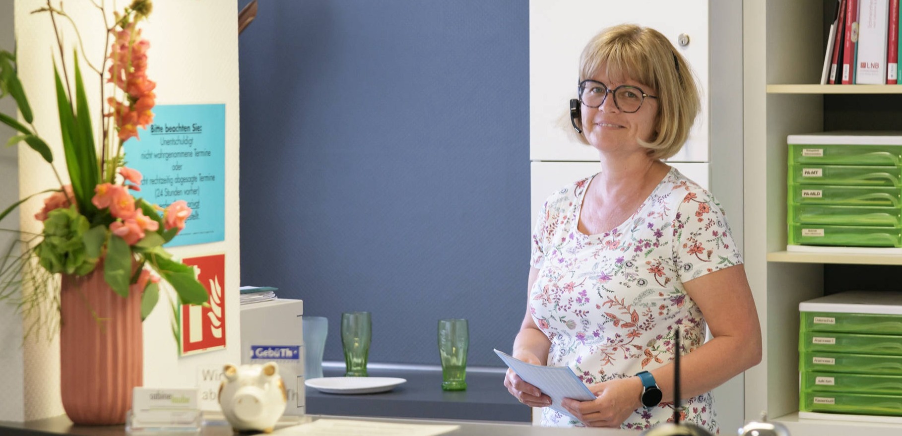 Mitarbeiterin mit Headset am Empfang der Physiotherapiepraxis Sabine Laube